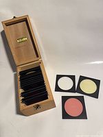 Open wooden box showing stacked filters and two filters outside