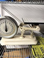 Full view of vintage white scale on shelving