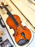 Open case showing Vizcaya violin, bow, rosin, spare strings