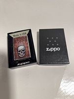 Zippo lighter in display sleeve alongside branded box