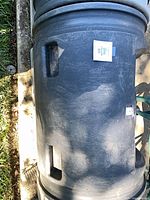 Top view of one compost barrel showing hand grips and surface wear