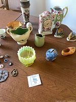 Wide view of assorted ceramics, glass bowl, piggy bank and trinkets on table