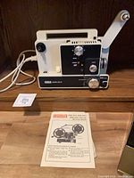Front view of Eumig Mark 610D projector with power cord and instruction sheet