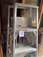 Pair of aluminum step ladders stacked together