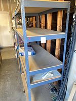 Side view of tall grey metal rack showing wood shelves