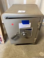 Front view of gray Sentry safe with handle and dial lock