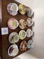12 assorted teacup and saucer sets on tabletop