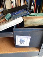 Blue case with drafting sets and other items in cardboard box