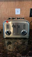 Front view of brushed stainless steel Cuisinart CPT-180 four-slot toaster showing control levers, knobs and buttons