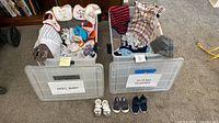 Two totes filled with assorted baby clothes, three pairs shoes lined in front