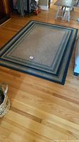 Full view of rectangular striped rug on wood floor