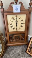 Front view of wooden wall clock and partial ornate frame
