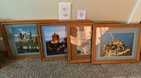 Four framed prints lined up against wall