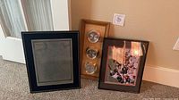 Overall view of the three framed items leaning against wall