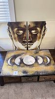 Front view of Buddha diptych behind moon phase canvas