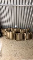 Six striped cushions leaned against wall, size comparison visible
