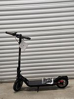 Full side profile of black 5TH WHEEL V30 Pro electric scooter standing folded out, charger/manual bag on deck visible