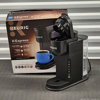 Keurig K-Express coffee maker with blue mug and retail box