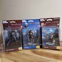 Front view of all three sealed TOTAKU figures: Kratos, Atreus, The Hunter