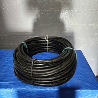 Full coil of black cable on blue surface