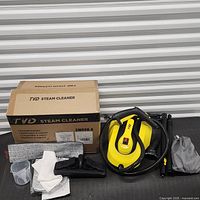Steam cleaner with accessories and box visible