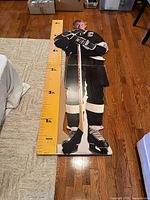 Full standee laid flat showing entire image and ruler scale