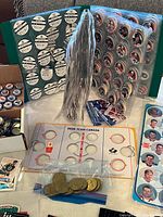 Binder with pages of pogs, loose pog stacks, Team Canada board, bag of tokens