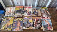 Twenty assorted motorcycle magazines spread on table showing covers