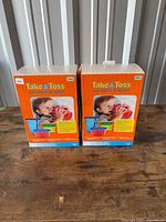 Front view of two sealed Take & Toss boxed sets on table
