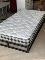 Twin mattress resting on black steel frame