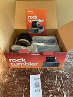 Open box showing tumbler components and manual