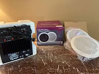 Quest QS8 amplifier module, Nexxtech speaker box and packaged speakers on table