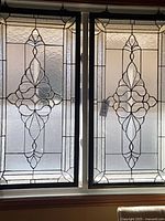 Front view of both matching clear beveled glass window panels hanging in window