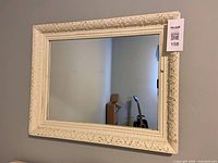 Full view of rectangular ornate wall mirror on wall