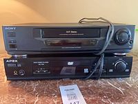 Sony SLV-940HF VCR stacked on APEX AD-700 DVD player with power cords visible