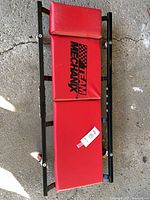 Top view showing red padded sections with Team Mechanix logo on black steel frame