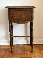 Front view of wooden end table showing door, legs and stretcher