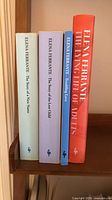 Four Elena Ferrante books upright on shelf