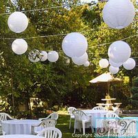 Hanging white paper lanterns in outdoor setting