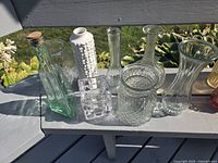 Group shot of eight assorted vases and bottle on bench