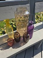 All six colored glass vases and bottles grouped together