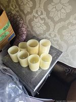 Seven ivory flameless LED pillar candles of varying heights on a table