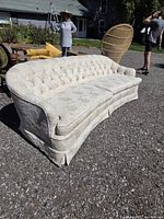 Front angle showing entire sofa, tufted back, curved shape and skirt