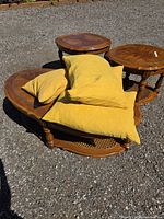 Four yellow-gold throw cushions stacked on outdoor surface