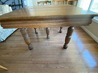 Side view of oak dining table showing legs and apron