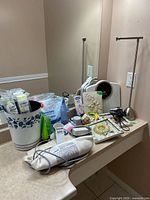 Full lot on countertop showing scale, waste bin, Epsom salts, cotton rounds, nightlight, heating pad, frames