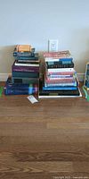 Two stacks of assorted books on floor, full lot view