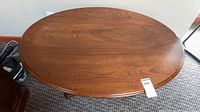 Top view of oval coffee table showing wood grain, finish, edge profile