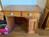 Front view of pine desk showing drawer with ceramic knobs and cabinet door