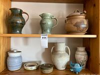 Shelf displaying nine pottery items
